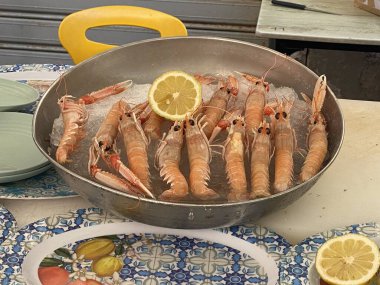Taze Nephrops Norvegicus, Norveç ıstakozu ya da karides olarak da bilinir, bir dilim limonla bir buz yatağında sunulur, Siracusa, Sicilya, İtalya 'da bir restoranda hazırlanmaya hazırdır.
