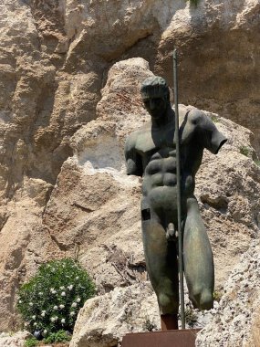 Bronz savaşçı heykeli mızrağı kavrıyor. Sicilya, Syracuse 'daki antik Latomie del Paradiso taş ocağının ortasında duruyor. Tarihi mirası temsil ediyor.
