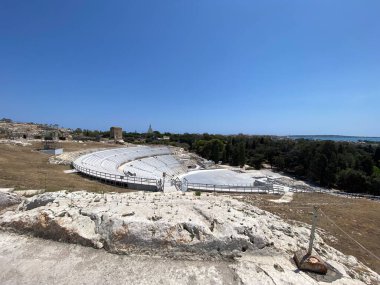 Neapolis arkeoloji parkına yerleşmiş, gök mavisi Akdeniz sularına bakan Yunan tiyatrosu, antik Syracuse 'un Sicilya kıyı manzarasına karşı dramatik manzarasını gözler önüne seriyor