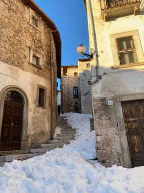 Santo Stefano di Sessanio, Abruzzo dağ köyündeki tarihi ortaçağ manzarasını tanımlayan dar kaldırım taşları, karla kaplı merdivenler...