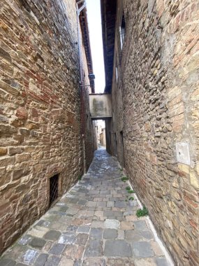 Ortaçağ Toskana köyünde dolambaçlı dar kaldırım geçidi taş duvarlar, kırsal mimari, Barberino Tavarnelle 'in tarihi cazibesi