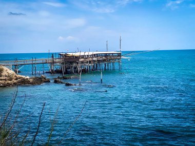 Trabocco adındaki ahşap balıkçı makinesi güneşli bir günde İtalya 'nın Abruzzo kentindeki Rocca San Giovanni kıyısında Adriyatik Denizi' nde duruyor.