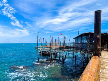 Adriyatik Denizi 'ni kapsayan geleneksel ahşap balıkçılık platformu mavi gökyüzü ve dağınık bulutlarla Abruzzo kıyılarını yakalıyor.