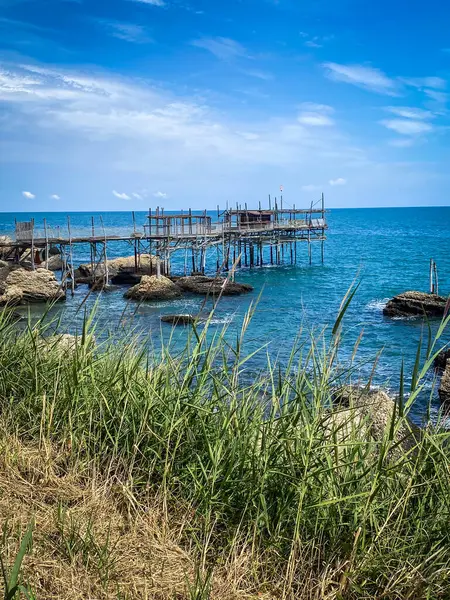 Geleneksel bir balıkçılık platformu olan Trabocco, İtalya 'nın Rocca San Giovanni kentindeki Adriyatik kıyısında mavi deniz ve gökyüzünün zeminine karşı duruyor.