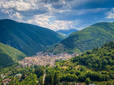 Gökyüzü manzarası, yeşil dağların arasına yerleşmiş Tarama 'yı yakalıyor. Geleneksel taş binalar, bulutlu yaz gökyüzünün altında Abruzzo manzarasını noktalıyor.