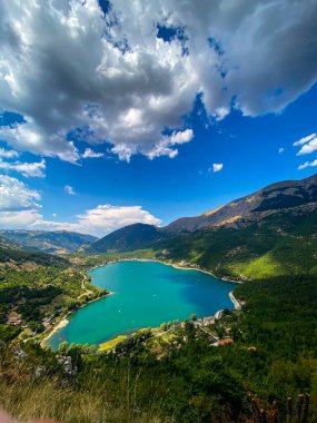 İtalya 'nın Abruzzo kentindeki yemyeşil arazi ve dağlık araziye yerleşmiş Scanno Gölü' nün ayna benzeri yüzeyini gösteren hava manzarası