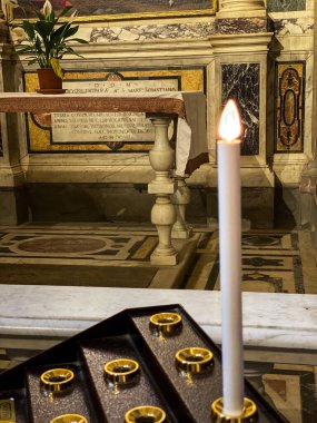 Elektrikli mum, antik bir mermer sunağın önünde Barberino Tavarnelle, Florence, Tuscany, İtalya 'daki bir kilisede Latince yazıyla yanıyor.
