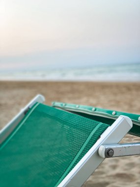 İtalya, Pineto 'nun kumlu sahilinde duran yeşil plaj sandalyesi Adriyatik Denizi' nin rahatlatıcı manzarasını sunuyor.