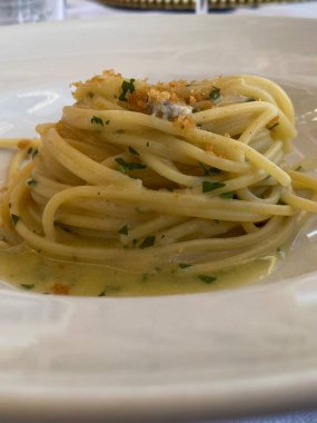 Kremalı deniz ürünleri sosuyla kaplanmış spagetti, taze maydanoz ve kızarmış ekmek kırıntıları. Geleneksel İtalyan cucina.