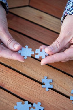 Kadının elinde yapboz parçaları var. İş kararları, başarı ve strateji kavramı. Ev yapbozu oyunu