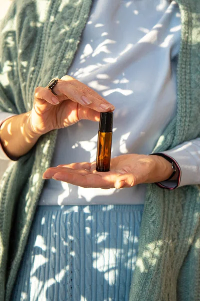 Güzel bir kadının elinde gerekli cam şişeler var. Kapat.