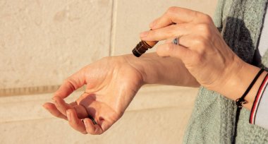 Doterra 'nın temel yağlarının editörlük görüntüsü. Bir kadının elinde esaslı bir yağ şişesi var. Bir silindir kullanarak. Karadağ, Kasım 2022