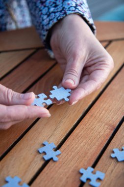 Kadının elinde yapboz parçaları var. İş kararları, başarı ve strateji kavramı. Ev yapbozu oyunu