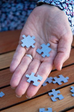 Kadının elinde yapboz parçaları var. İş kararları, başarı ve strateji kavramı. Ev yapbozu oyunu