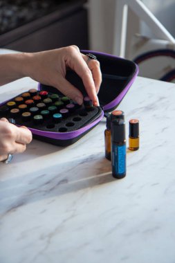 Tivat, Karadağ - Kasım 2022: Doterra Esnecessary Oils 'in editoryal görüntüsü. Bir kadının elinde gerekli yağ şişesi. Doğal ilaçlar, sağlık.