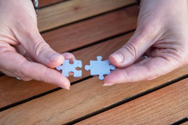 Kadının elinde yapboz parçaları var. İş kararları, başarı ve strateji kavramı. Ev yapbozu oyunu