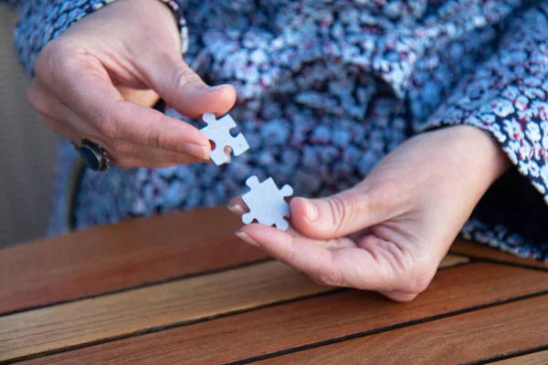 Kadının elinde yapboz parçaları var. İş kararları, başarı ve strateji kavramı. Ev yapbozu oyunu