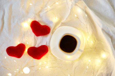 Sevgililer Günü kahvesi kırmızı kalpler ve ışıklarla dolu, kopyalama alanı. Tebrik kartı, romantik kahvaltı..