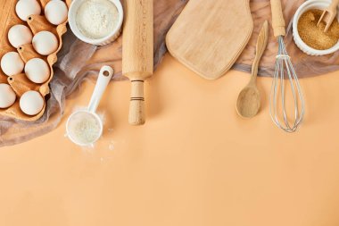 Pastane, mutfak iskeleti, malzemeler, pastel turuncu arka planda hamur işi için mutfak malzemeleri. Üst görünüm, alanı kopyala.