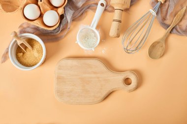 Pastane, mutfak iskeleti, malzemeler, pastel turuncu arka planda hamur işi için mutfak malzemeleri. Üst görünüm, alanı kopyala.