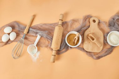 Pastane, mutfak iskeleti, malzemeler, pastel turuncu arka planda hamur işi için mutfak malzemeleri. Üst görünüm, alanı kopyala.