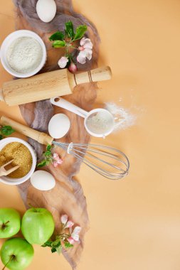 Pastane veya elmalı fırın çerçevesi, malzemeler, pastel turuncu arka planda hamur işi için mutfak malzemeleri, bahar pişirme teması. Üst görünüm, alanı kopyala.