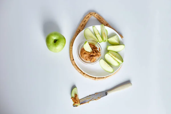 stock image Green slices apples with peanut butter on white background, healthy snack, nutrition food, diet