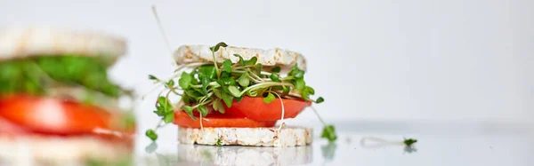 Banner  Healthy burger with crispy rice bread vegetables tomato and microgreens on white background, vegan nutrtional, diet food