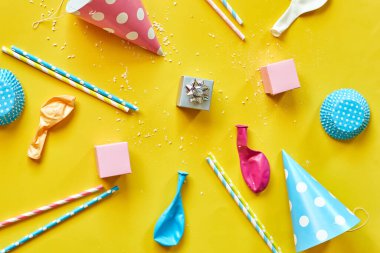 Flat lay festival birthday party background with gift box with various party, balloons, decorations on a yellow background, Happy Birthday party concept