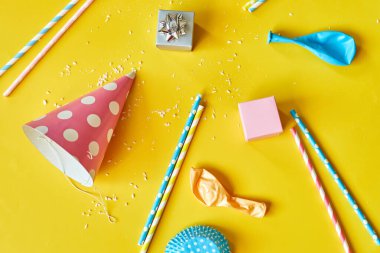 Flat lay festival birthday party background with gift box with various party, balloons, decorations on a yellow background, Happy Birthday party concept