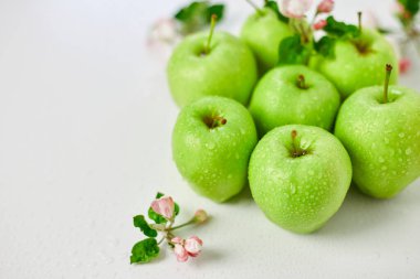 Düz elma çiçekleri ve olgun yeşil elmalar beyaz arka planda, meyveler ve çiçekler, sping konsepti. Üst görünüm