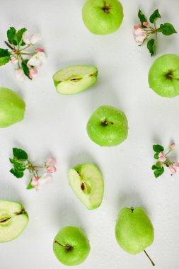Düz elma çiçekleri ve olgun yeşil elmalar beyaz arka planda, meyveler ve çiçekler, sping konsepti. Üst görünüm