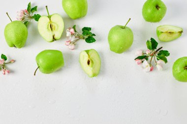 Düz elma çiçekleri ve olgun yeşil elmalar beyaz arka planda, meyveler ve çiçekler, sping konsepti. Üst görünüm