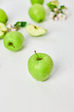 Düz elma çiçekleri ve olgun yeşil elmalar beyaz arka planda, meyveler ve çiçekler, sping konsepti. Üst görünüm