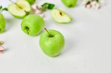Düz elma çiçekleri ve olgun yeşil elmalar beyaz arka planda, meyveler ve çiçekler, sping konsepti. Üst görünüm