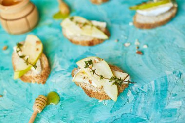 Bruschetta antipasto with blue cheese and pear on blue background, top view, vegetarian food