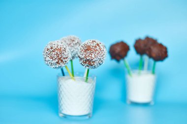 Delicious homemade popcake coconut and dark chocolate cake pops on a blue background, festival desserts, tasty food