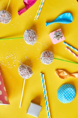 Festival birthday background with delicious homemade popcake coconut chocolate cake pops on a yellow background, festival desserts, tasty food