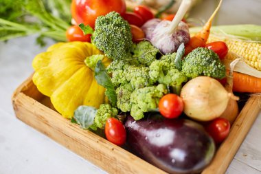 Wooden box with different fresh farm vegetables on the white background, Autumn harvest and healthy organic bio food concept, Garden produce and harvested vegetable