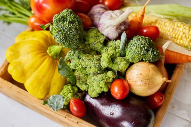 Wooden box with different fresh farm vegetables on the white background, Autumn harvest and healthy organic bio food concept, Garden produce and harvested vegetable