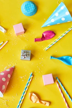 Flat lay festival birthday party background with gift box with various party, balloons, decorations on a yellow background, Happy Birthday party concept