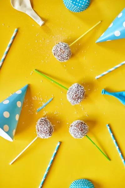 Festival birthday blue boy background with delicious homemade popcake coconut chocolate cake pops on a yellow background, festival desserts, tasty food