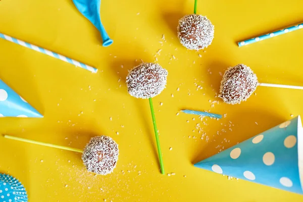 Festival birthday blue boy background with delicious homemade popcake coconut chocolate cake pops on a yellow background, festival desserts, tasty food