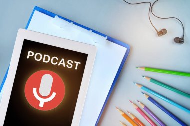 Podcast ve mikrofon dijital tablette, beyaz kağıtta, kulaklık ve kalemle gösteriliyor. Metaverse konsepti ve fikir dinlemeyi öğren