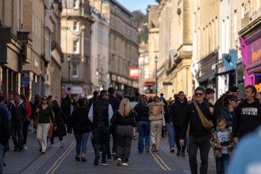 Bath, İngiltere, 15 Ekim 2023: İnsanlar Bath, İngiltere 'de şehrin alışveriş bölgesinde bir cadde boyunca yürüyorlar. Burası İngiltere 'nin ünlü tarihi şehri.