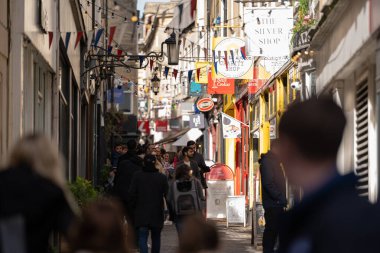 Bath, İngiltere, 15 Ekim 2023: İnsanlar Bath, İngiltere 'de şehrin alışveriş bölgesinde bir cadde boyunca yürüyorlar. Burası İngiltere 'nin ünlü tarihi şehri.