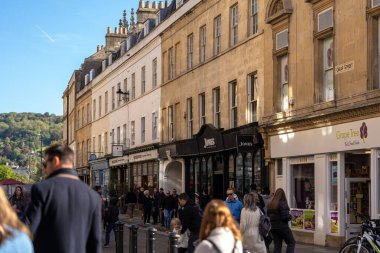 Bath, İngiltere, 15 Ekim 2023: İnsanlar Bath, İngiltere 'de şehrin alışveriş bölgesinde bir cadde boyunca yürüyorlar. Burası İngiltere 'nin ünlü tarihi şehri.
