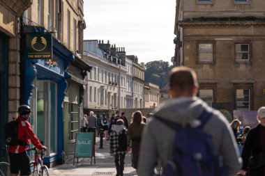 Bath, İngiltere, 15 Ekim 2023: İnsanlar Bath, İngiltere 'de şehrin alışveriş bölgesinde bir cadde boyunca yürüyorlar. Burası İngiltere 'nin ünlü tarihi şehri.