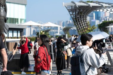 Hong Kong, Çin: 3 Ocak 2024: Yıldızlar Bulvarı 'nı ziyaret eden turistler. Yıldız Bulvarı, Hong Kong 'daki Victoria Limanı boyunca yer almaktadır. 