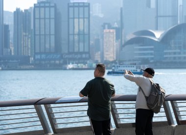 Hong Kong, Çin: 3 Ocak 2024: Yıldızlar Bulvarı 'nı ziyaret eden turistler. Yıldız Bulvarı, Hong Kong 'daki Victoria Limanı boyunca yer almaktadır. 